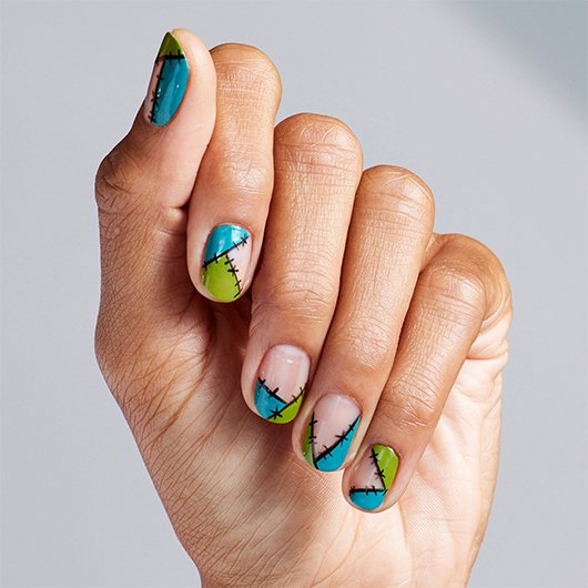medium skin hand with monster nail art created with blue and green essie nail polish