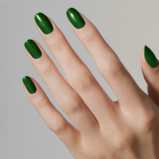 Light skin hand with nails painted in essie's emerald green seize the crown nail polish