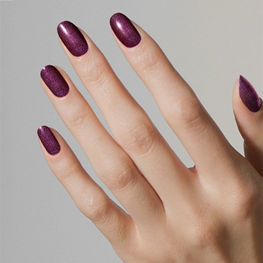 Light skin hand wearing pearly eggplant purple tempted with envy essie nail polish